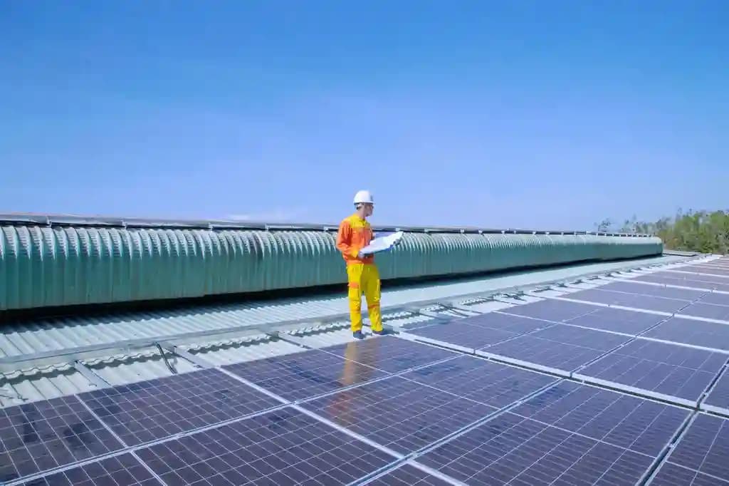 Drone thermal sedang melakukan inspeksi panel surya di atas atap.