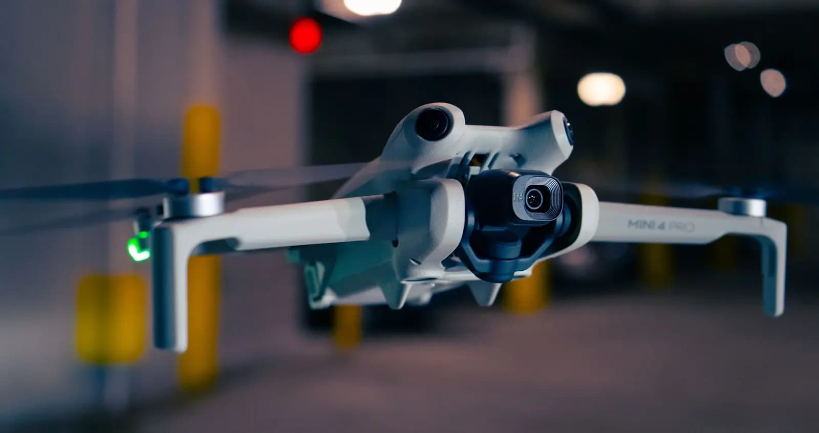 DJI Mini 4 Pro terbang di atas pemandangan alam dengan latar belakang pegunungan