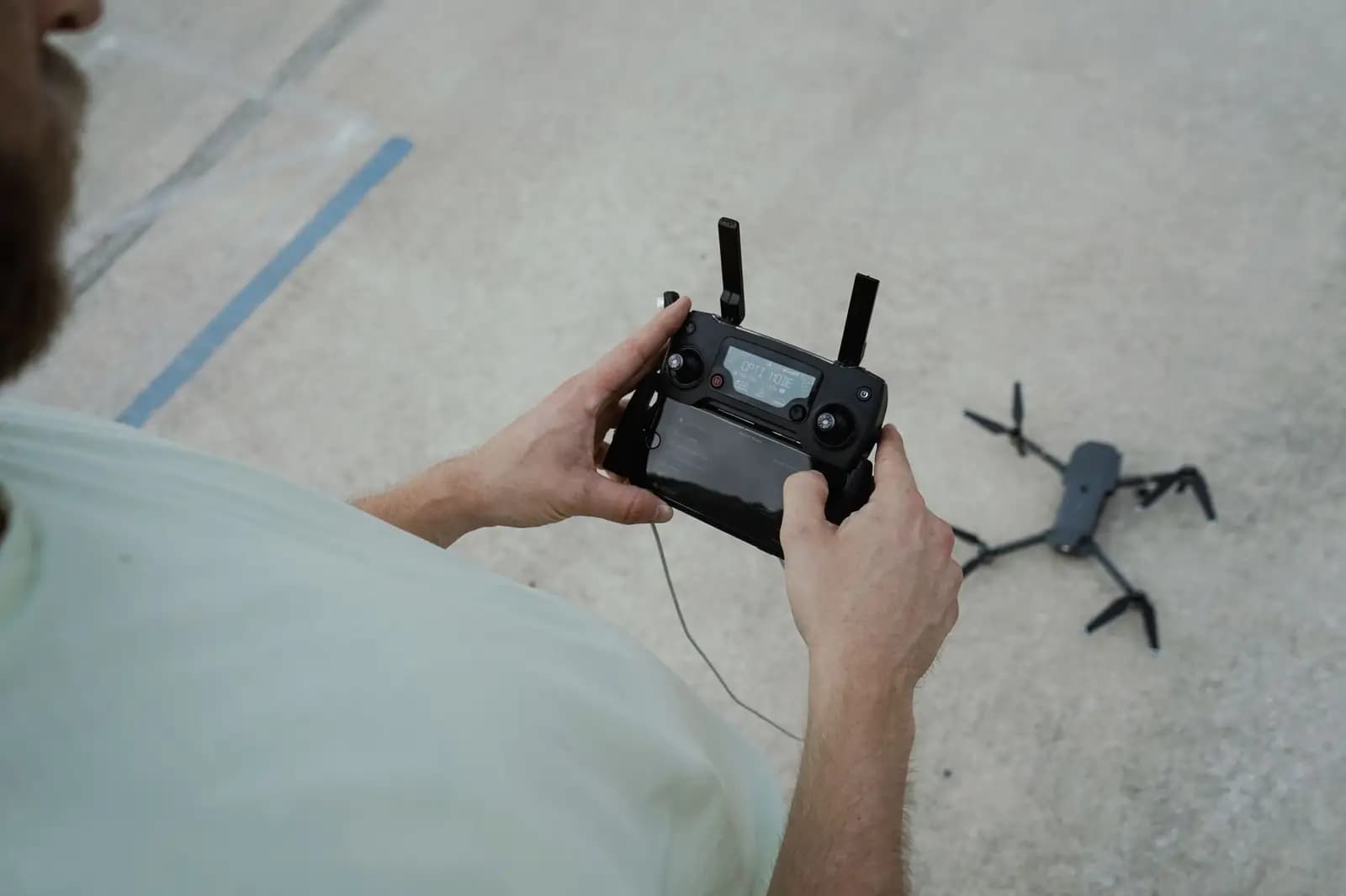 Seorang remote pilot profesional memegang sertifikat di lokasi operasi drone.