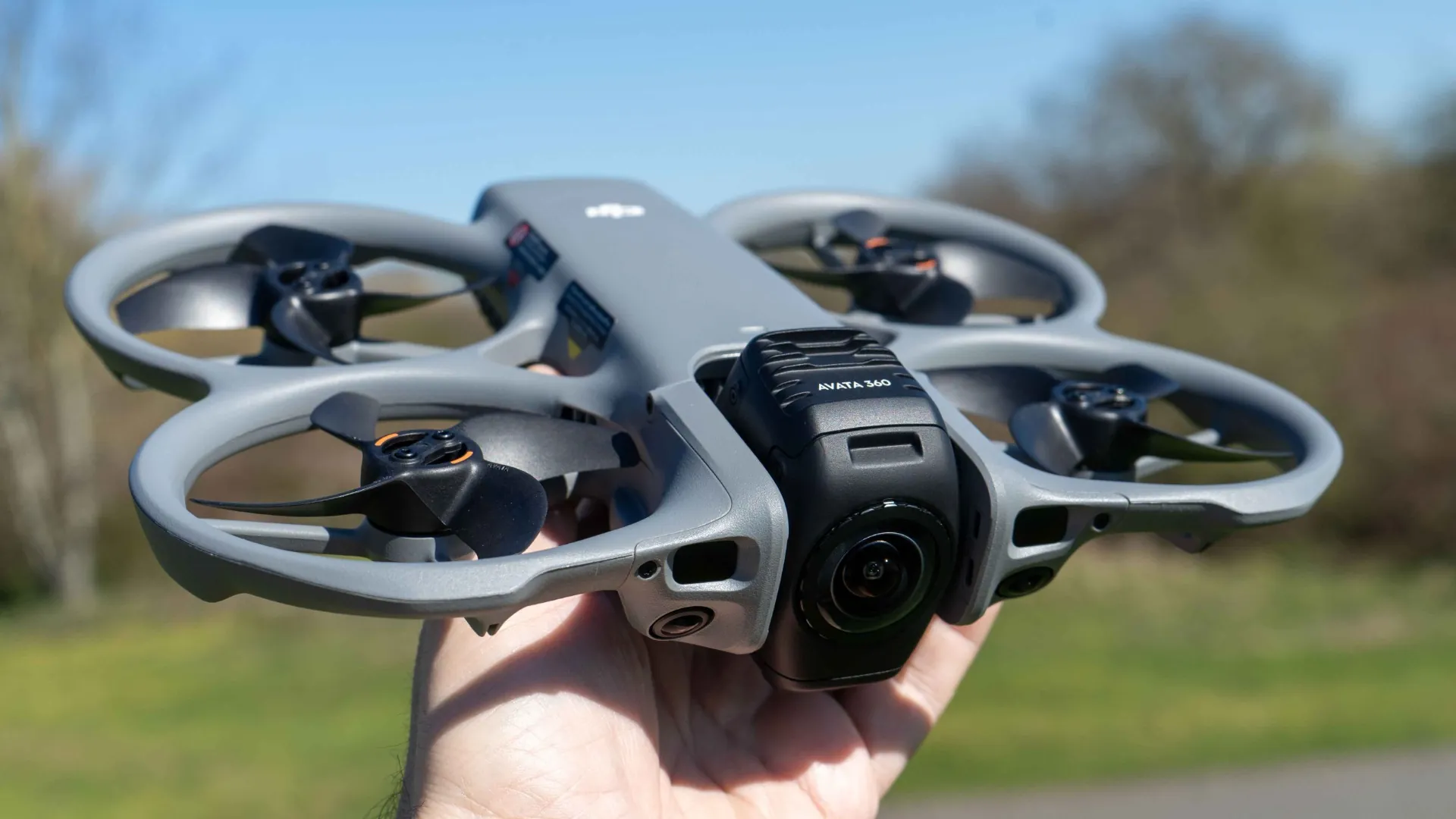 DJI Avata 360 dipegang tangan menampilkan kamera dual fisheye 360 derajat