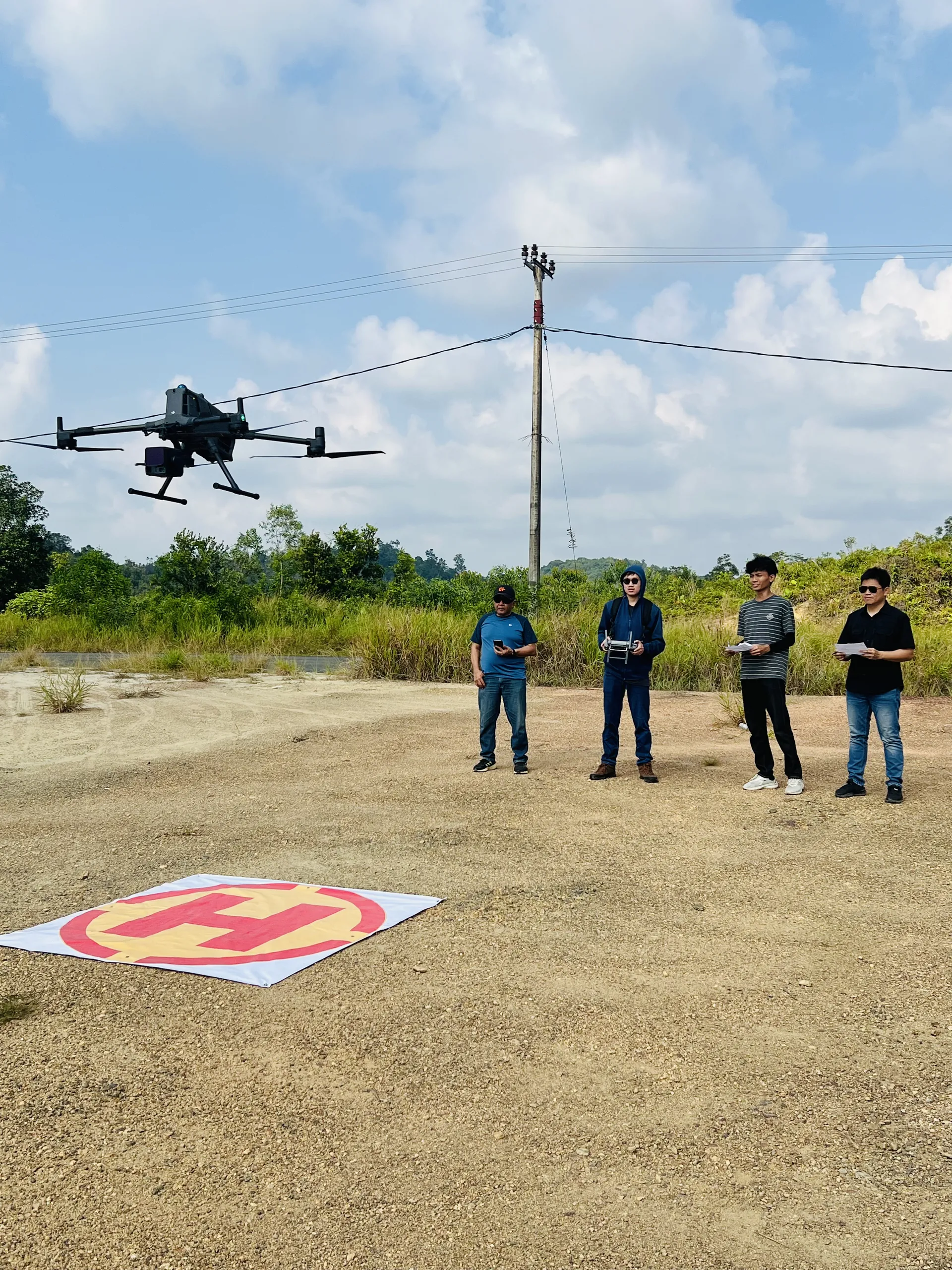 Peserta pelatihan mengamati penerbangan drone Matrice 400 saat praktik lapangan