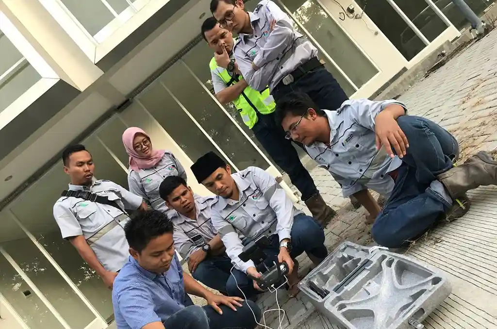 Kelompok peserta pelatihan menyiapkan drone dan remote control untuk praktik lapangan
