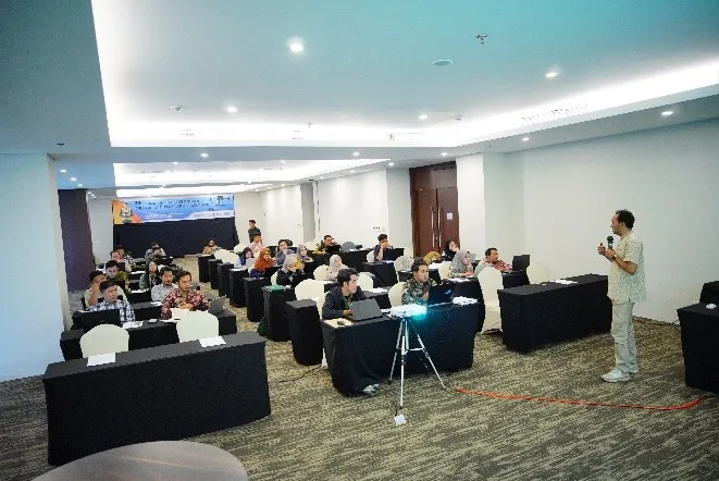 Instruktur memberikan materi regulasi penerbangan di depan peserta pelatihan drone dalam ruang kelas yang luas