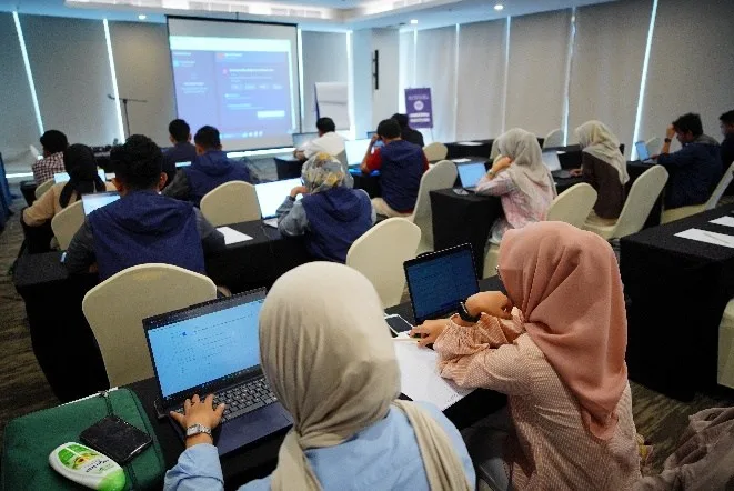 Peserta pelatihan mengerjakan modul teori penerbangan drone menggunakan laptop di kelas sertifikasi