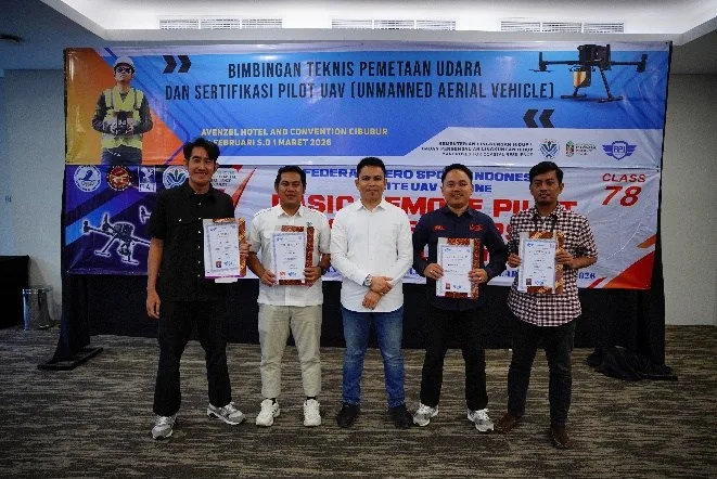 Peserta dan instruktur berfoto bersama di depan banner kegiatan Bimbingan Teknis Pemetaan Udara dan Sertifikasi Pilot UAV di Avenzel Hotel Cibubur