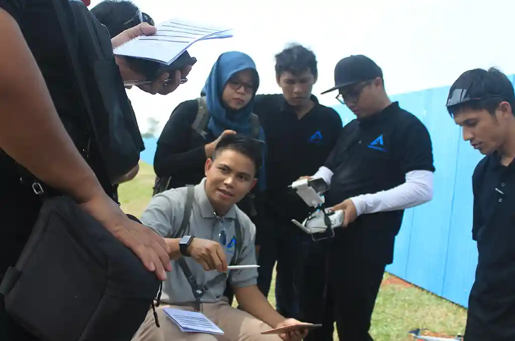 Peserta pelatihan memeriksa peralatan drone sebelum praktik lapangan pemetaan